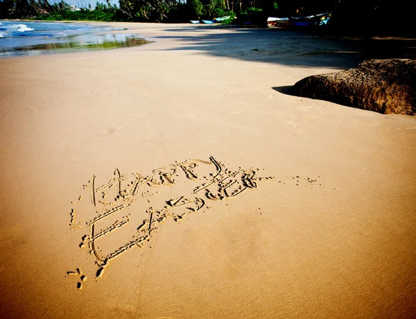 Easter bunny and eggs drawn in sand on tropical beach — Stock Photo, Image