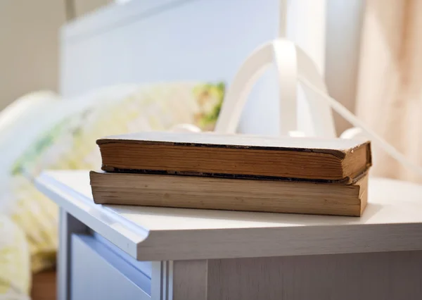 Slaapkamer met boeken over nachtkastje — Stockfoto