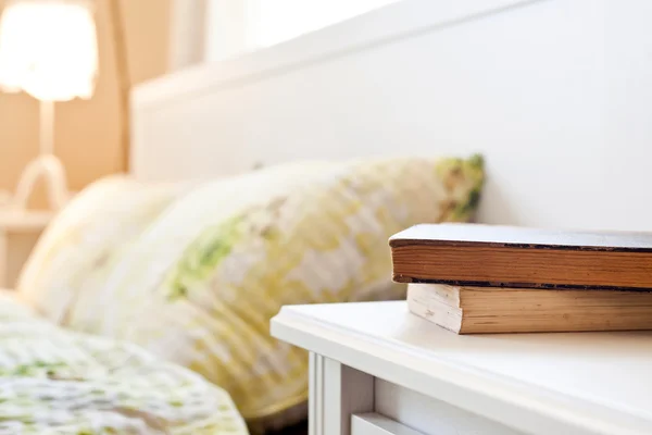 Dormitorio con libros en la mesita de noche —  Fotos de Stock