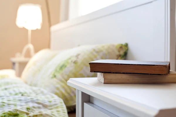 Dormitorio con libros en la mesita de noche —  Fotos de Stock