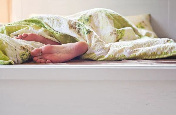 Close-up de dois pés em uma cama - sono relaxante — Fotografia de Stock