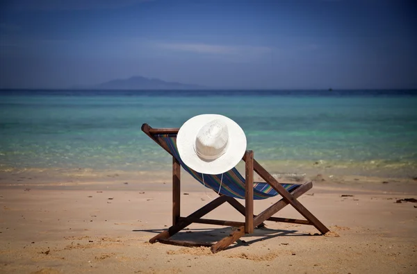 Exotiska beach holiday bakgrund med vit hat på strandstol — Stockfoto