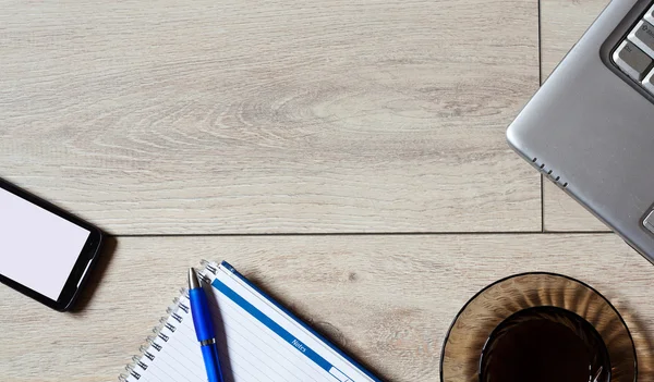 Mesa de oficina con portátil, teléfono, portátil y taza de café — Foto de Stock