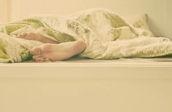 Close-up de dois pés em uma cama - sono relaxante — Fotografia de Stock