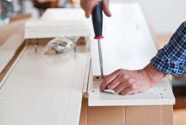 Düz paket mobilya monte eden adam