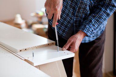 Düz paket mobilya monte eden adam