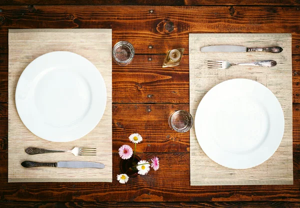 Table setting for two with empty plates - rustic wooden table — Stock Photo, Image