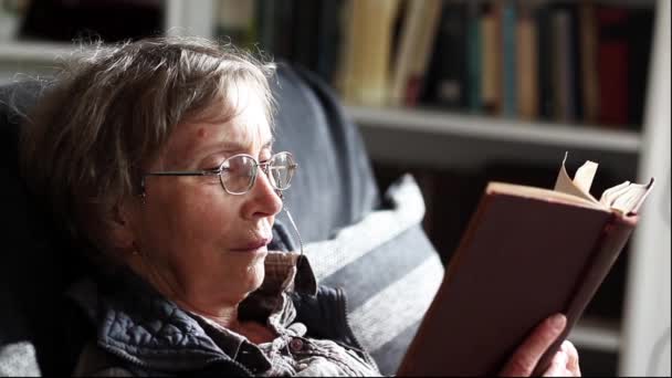 Mulher aposentada feliz lendo um livro Videoclipe
