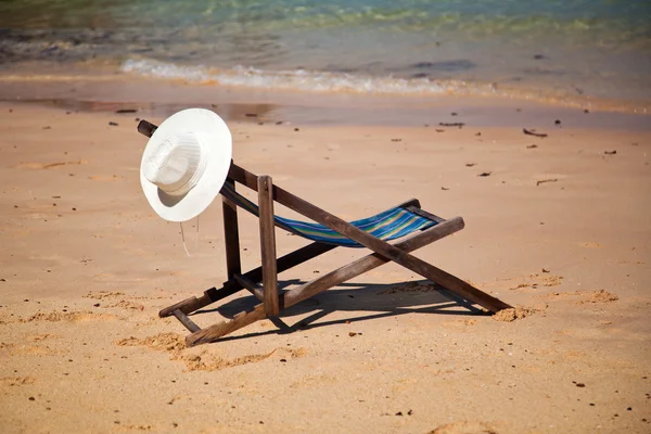 Exotic beach holiday background with white hate on beach chair — Stock Photo, Image