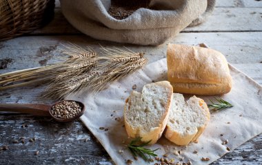 Tahta masada taze ekmek ve buğday.