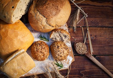 Tahta masada taze ekmek ve buğday.