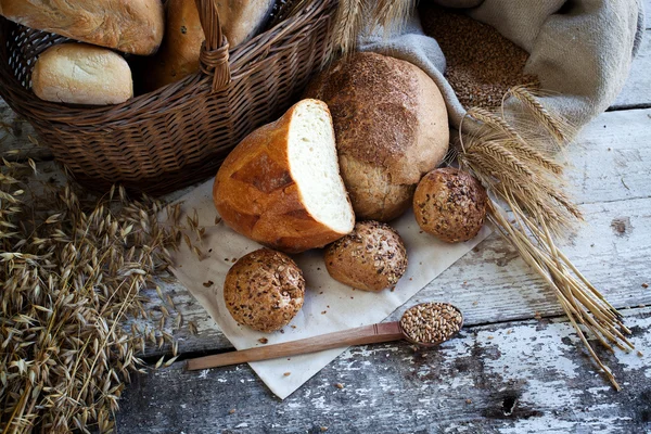 Свежий хлеб и пшеница на деревянном столе — стоковое фото