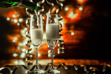 iki şampanya bardağı şeritler tatil ışıklar ve havai fişek - yeni yıl kutlamaları karşı