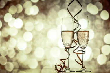 iki şampanya bardağı şeritler tatil ışıklar ve havai fişek - yeni yıl kutlamaları karşı