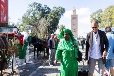 MARRAKESH, MOROCCO - 4 Aralık 2025: Yerliler ve turistler, Unesco dünya mirasının bir parçası olan Marakeş eski Medine sokaklarında ve geleneksel pazarlarda günlük işlerine devam ediyorlar