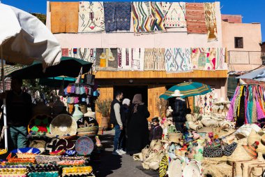 MARRAKESH, MOROCCO - 4 Aralık 2025: Yerliler ve turistler, Unesco dünya mirasının bir parçası olan Marakeş eski Medine sokaklarında ve geleneksel pazarlarda günlük işlerine devam ediyorlar