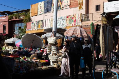 MARRAKESH, MOROCCO - 4 Aralık 2025: Yerliler ve turistler, Unesco dünya mirasının bir parçası olan Marakeş eski Medine sokaklarında ve geleneksel pazarlarda günlük işlerine devam ediyorlar