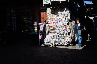 MARRAKESH, MOROCCO - 4 Aralık 2025: Yerliler ve turistler, Unesco dünya mirasının bir parçası olan Marakeş eski Medine sokaklarında ve geleneksel pazarlarda günlük işlerine devam ediyorlar