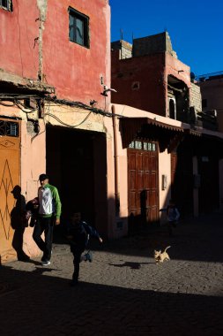 MARRAKESH, MOROCCO - 4 Aralık 2025: Yerliler ve turistler, Unesco dünya mirasının bir parçası olan Marakeş eski Medine sokaklarında ve geleneksel pazarlarda günlük işlerine devam ediyorlar