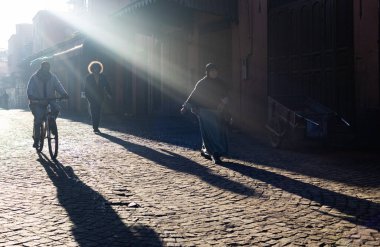 MARRAKESH, MOROCCO - 4 Aralık 2025: Yerliler ve turistler, Unesco dünya mirasının bir parçası olan Marakeş eski Medine sokaklarında ve geleneksel pazarlarda günlük işlerine devam ediyorlar