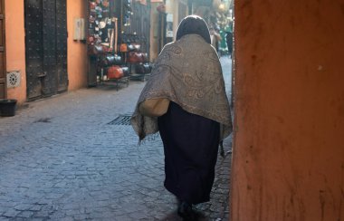 MARRAKESH, MOROCCO - 4 Aralık 2025: Yerliler ve turistler, Unesco dünya mirasının bir parçası olan Marakeş eski Medine sokaklarında ve geleneksel pazarlarda günlük işlerine devam ediyorlar