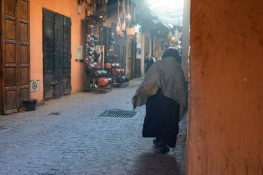 MARRAKESH, MOROCCO - 4 Aralık 2025: Yerliler ve turistler, Unesco dünya mirasının bir parçası olan Marakeş eski Medine sokaklarında ve geleneksel pazarlarda günlük işlerine devam ediyorlar
