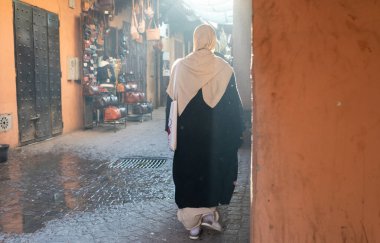 MARRAKESH, MOROCCO - 4 Aralık 2025: Yerliler ve turistler, Unesco dünya mirasının bir parçası olan Marakeş eski Medine sokaklarında ve geleneksel pazarlarda günlük işlerine devam ediyorlar