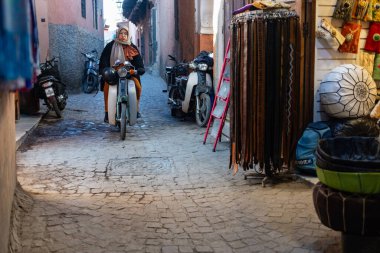 MARRAKESH, MOROCCO - 4 Aralık 2025: Yerliler ve turistler, Unesco dünya mirasının bir parçası olan Marakeş eski Medine sokaklarında ve geleneksel pazarlarda günlük işlerine devam ediyorlar