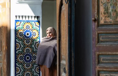 MARRAKESH, MOROCCO - 4 Aralık 2025: Yerliler ve turistler, Unesco dünya mirasının bir parçası olan Marakeş eski Medine sokaklarında ve geleneksel pazarlarda günlük işlerine devam ediyorlar