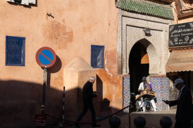 MARRAKESH, MOROCCO - 4 Aralık 2025: Yerliler ve turistler, Unesco dünya mirasının bir parçası olan Marakeş eski Medine sokaklarında ve geleneksel pazarlarda günlük işlerine devam ediyorlar