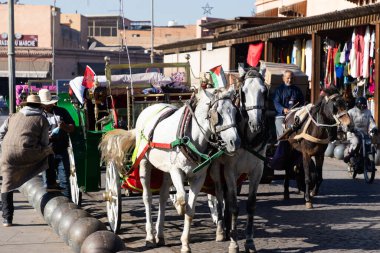 MARRAKESH, MOROCCO - 4 Aralık 2025: Yerliler ve turistler, Unesco dünya mirasının bir parçası olan Marakeş eski Medine sokaklarında ve geleneksel pazarlarda günlük işlerine devam ediyorlar