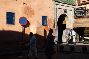 MARRAKESH, MOROCCO - 4 Aralık 2025: Yerliler ve turistler, Unesco dünya mirasının bir parçası olan Marakeş eski Medine sokaklarında ve geleneksel pazarlarda günlük işlerine devam ediyorlar