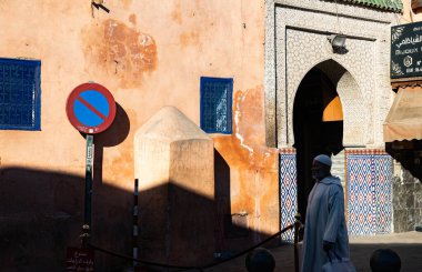 MARRAKESH, MOROCCO - 4 Aralık 2025: Yerliler ve turistler, Unesco dünya mirasının bir parçası olan Marakeş eski Medine sokaklarında ve geleneksel pazarlarda günlük işlerine devam ediyorlar