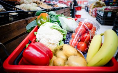 Süpermarkette alışveriş arabası dolusu yiyecek.