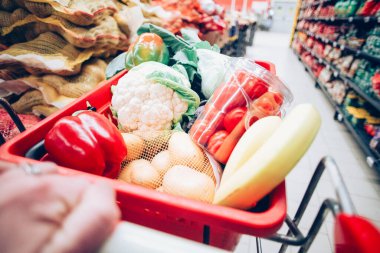Süpermarkette alışveriş arabası dolusu yiyecek.
