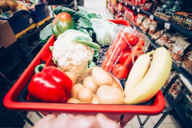 Süpermarkette alışveriş arabası dolusu yiyecek.