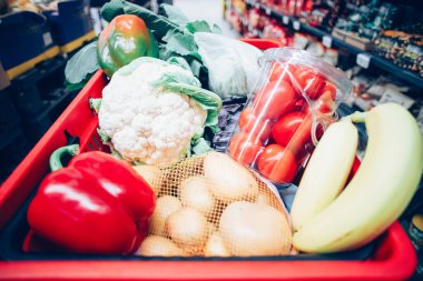 Süpermarkette alışveriş arabası dolusu yiyecek.