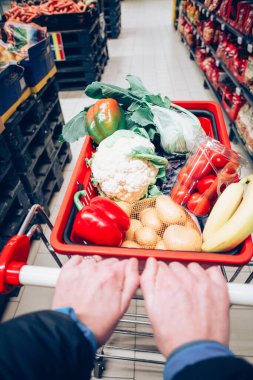 Süpermarkette alışveriş arabası dolusu yiyecek.