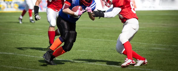 American football game with out of focus players in the backgrou — Stock Photo, Image