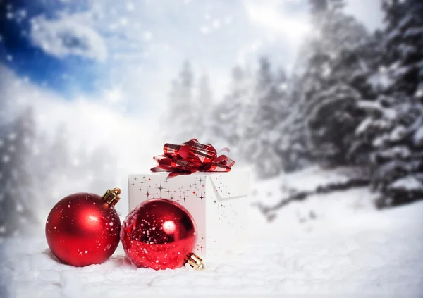 Decorações de Natal e caixa de presente na neve - abetos nevados no b — Fotografia de Stock