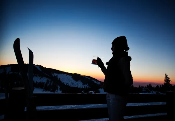 Apres esqui, férias de inverno - jovem mulher bebendo vinho ao pôr do sol — Fotografia de Stock