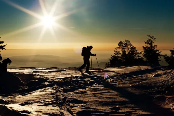 Narciarz backcountry, osiągając szczyt w zachód słońca — Zdjęcie stockowe