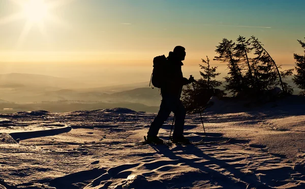 Backcountry-Skifahrer erreicht den Gipfel bei Sonnenuntergang — Stockfoto