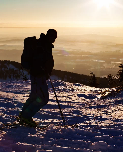 Esquiador de fundo que chega à cimeira ao pôr do sol — Fotografia de Stock