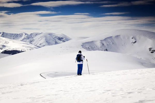Esquiador de fondo - montañas nevadas en el fondo — Foto de Stock