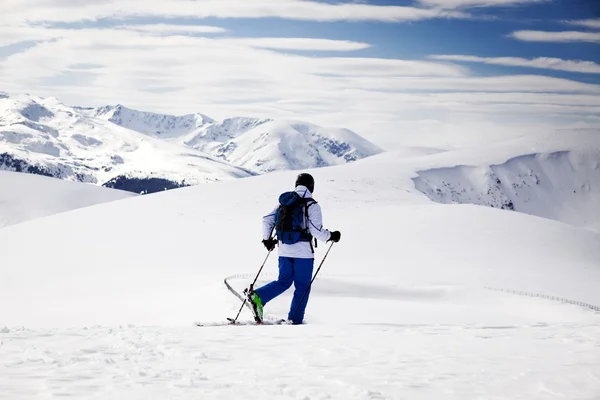 Längdskidåkare - snöiga bergen i bakgrunden — Stockfoto