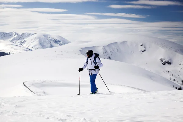 Cross-country skier - snowy mountains in the background — Stock Photo, Image