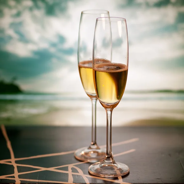 Champagne glasses on tropical beach at sunset - exotic New Year — Stock Photo, Image