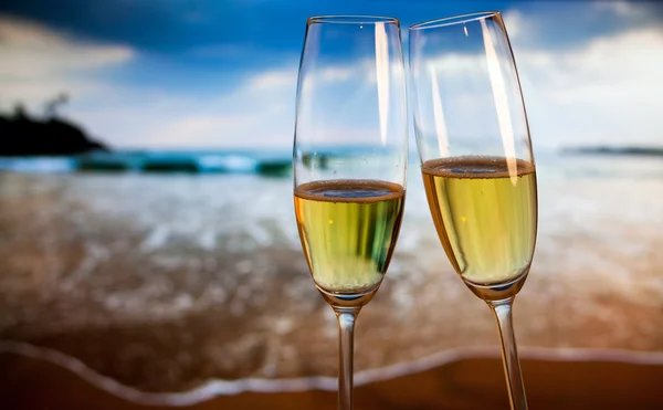 Champagneglazen op tropisch strand bij zonsondergang - exotische Nieuwjaar — Stockfoto