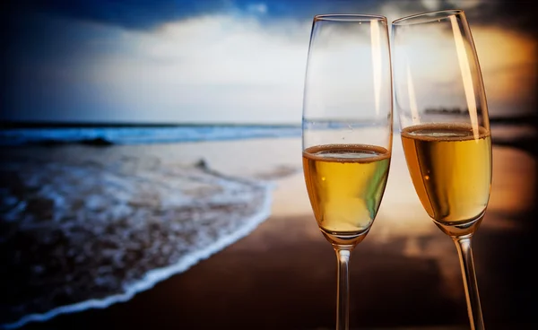 Gün batımında - egzotik yeni yıl tropik sahilde şampanya bardağı